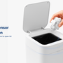 Hand dropping trash into a motion-activated smart trash can labeled 'Seamless Sensor Activation' with the lid automatically opening.