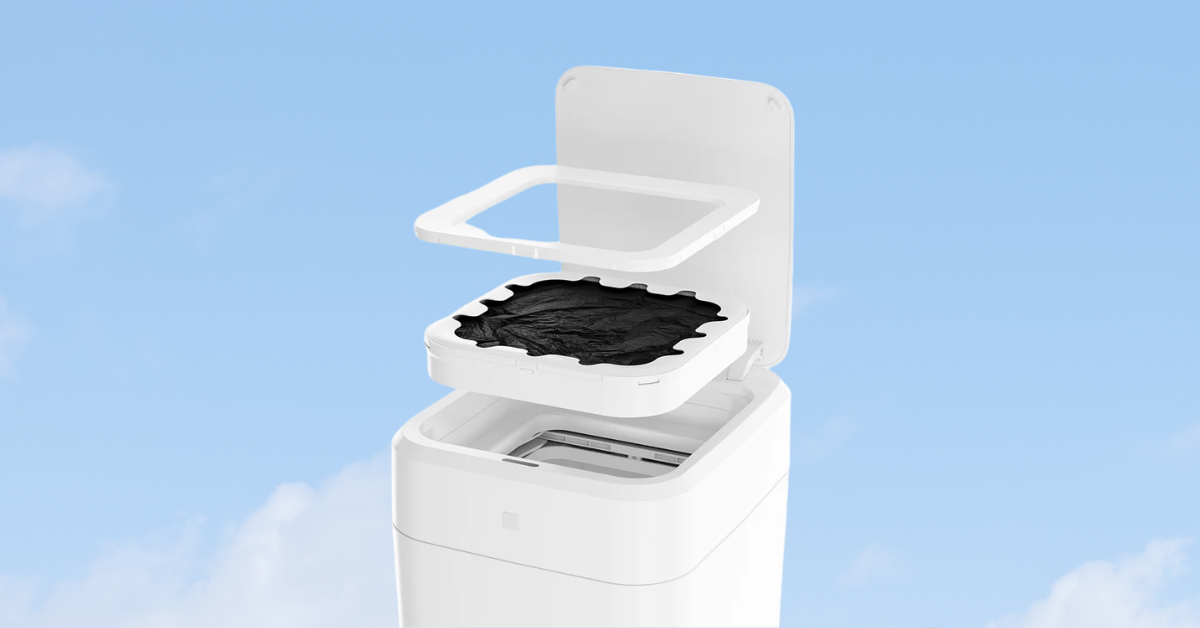 Smart trash can in mid-process of self-creating a new trash bag, shown with lid open and refill film visible against a blue sky background.