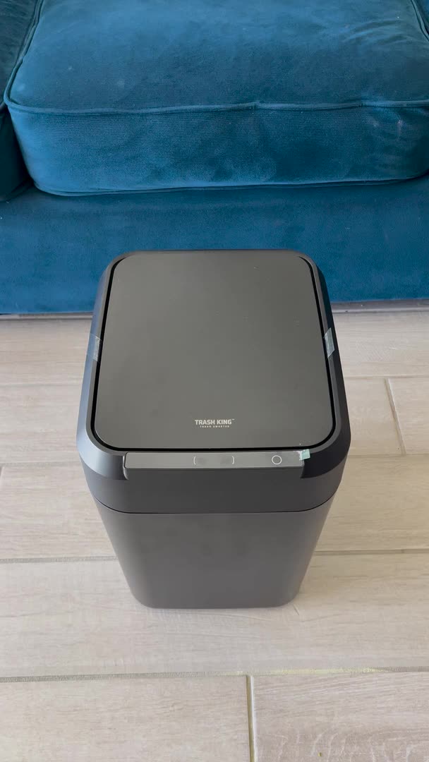 A hand waves in front of the Royal Bin® NOIR 17L, the lid opens, trash goes in, and the lid closes on its own
